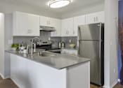 Thumbnail 1 of 30 - Bright kitchen with white cabinets and stainless steel refrigerator at The Villas at Northstar apartments for rent in Ann Arbor, MI