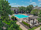 Thumbnail 13 of 30 - A pool surrounded by trees and a fence.
