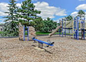Thumbnail 18 of 30 - A playground with a slide, swings, and a seesaw.