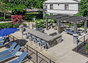 Thumbnail 25 of 30 - A patio with a table and chairs under a roof.