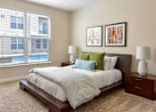 Thumbnail 7 of 22 - A bedroom with a large bed and two lamps.