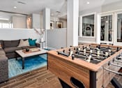 Thumbnail 17 of 22 - A foosball table sits in the middle of a living room.