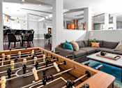 Thumbnail 18 of 22 - A foosball table is in the middle of a living room.