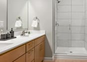 Thumbnail 14 of 61 - A bathroom with a white sink and a glass shower stall.