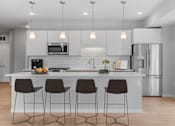 Thumbnail 17 of 61 - A modern kitchen with a white countertop and bar stools.