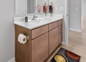 Thumbnail 18 of 61 - A bathroom with a sink, mirror, and wooden cabinet.