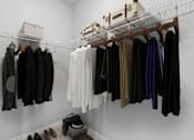 Thumbnail 35 of 61 - A white closet with clothes hanging and shoes on the floor.