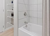 Thumbnail 39 of 61 - A white bathroom with a white tub and a white shower curtain.