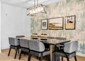 Thumbnail 30 of 61 - A dining table with grey chairs and a hanging light fixture.