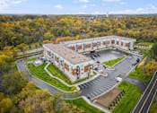 Thumbnail 45 of 61 - A large building with a parking lot in front of it.