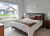 Thumbnail 5 of 76 - A bedroom with a large bed and a window overlooking a house.