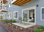 Thumbnail 12 of 76 - A blue house with a green chair on the patio.