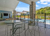 Thumbnail 17 of 76 - A patio with a table and chairs overlooking a pool.