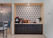Thumbnail 25 of 76 - A modern kitchen with a wooden chair and a patterned wallpaper.
