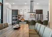Thumbnail 29 of 76 - A modern kitchen with a wooden table and chairs.