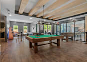 Thumbnail 39 of 76 - A billiard table is in the middle of a room with a wooden floor and ceiling.