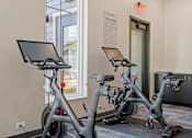 Thumbnail 51 of 76 - Two stationary bikes are in a room with a sign that says "Exercise Center".