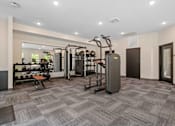Thumbnail 53 of 76 - A gym with a variety of equipment including a treadmill, weights, and a bench.