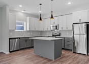Thumbnail 55 of 76 - A modern kitchen with a central island and stainless steel appliances.