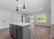 Thumbnail 58 of 76 - A kitchen with a large island and pendant lights.