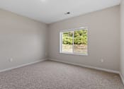 Thumbnail 60 of 76 - A room with a window showing greenery outside.