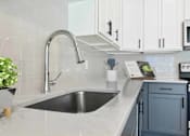 Thumbnail 70 of 76 - A kitchen with a sink and a plant.