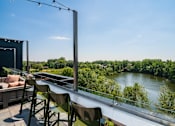 Thumbnail 18 of 32 - A balcony with chairs and a table overlooking a river.