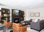 Thumbnail 20 of 32 - A living room with a fireplace, a couch, and a television.