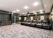 Thumbnail 24 of 32 - A home theater with a row of black leather seats and a ceiling fan.