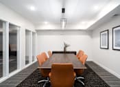 Thumbnail 22 of 32 - A conference room with a long table and orange chairs.