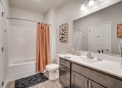 Thumbnail 9 of 32 - A bathroom with a toilet, sink, and shower.