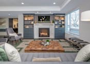 Thumbnail 17 of 30 - A modern living room with a fireplace and grey couches.
