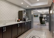 Thumbnail 26 of 30 - A kitchen with dark wood cabinets and a white countertop.