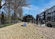 Thumbnail 24 of 30 - A residential area with a fenced yard and a car parked on the side.