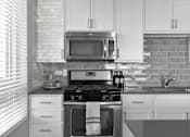 Thumbnail 3 of 30 - Modern kitchen with white cabinets at Park 205 Park Ridge Apartments