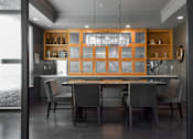 Thumbnail 27 of 30 - A modern kitchen with a dining table and chairs.