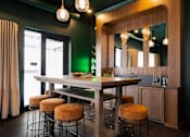Thumbnail 21 of 43 - A kitchen with a table and stools.