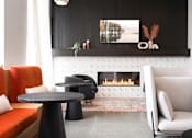Thumbnail 38 of 43 - A modern living room with a fireplace and a painting on the wall.