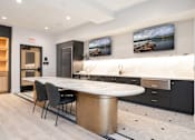 Thumbnail 39 of 43 - A modern kitchen with a dining table and chairs.