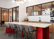 Thumbnail 40 of 43 - A modern kitchen with a long island and chairs.