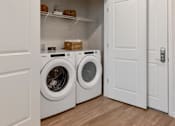 Thumbnail 7 of 42 - Two washing machines are in a white laundry room.