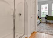 Thumbnail 11 of 42 - A white bathroom with a glass shower door and a white door.