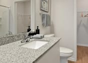 Thumbnail 12 of 42 - A bathroom with a sink, toilet, and a mirror.
