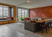 Thumbnail 24 of 42 - A modern living room with a wooden accent wall and a grey sofa.