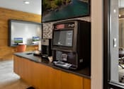 Thumbnail 28 of 42 - A modern office with a wooden wall and a large screen on the counter.