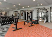 Thumbnail 34 of 42 - A gym with orange flooring and various exercise equipment.