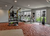 Thumbnail 35 of 42 - A gym with a red floor and various exercise equipment.
