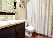 Thumbnail 12 of 43 - A white toilet sits next to a sink in a bathroom.