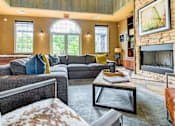 Thumbnail 31 of 43 - A living room with a grey couch and a fireplace.