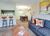 Thumbnail 3 of 43 - A living room with a grey couch and a wooden coffee table.